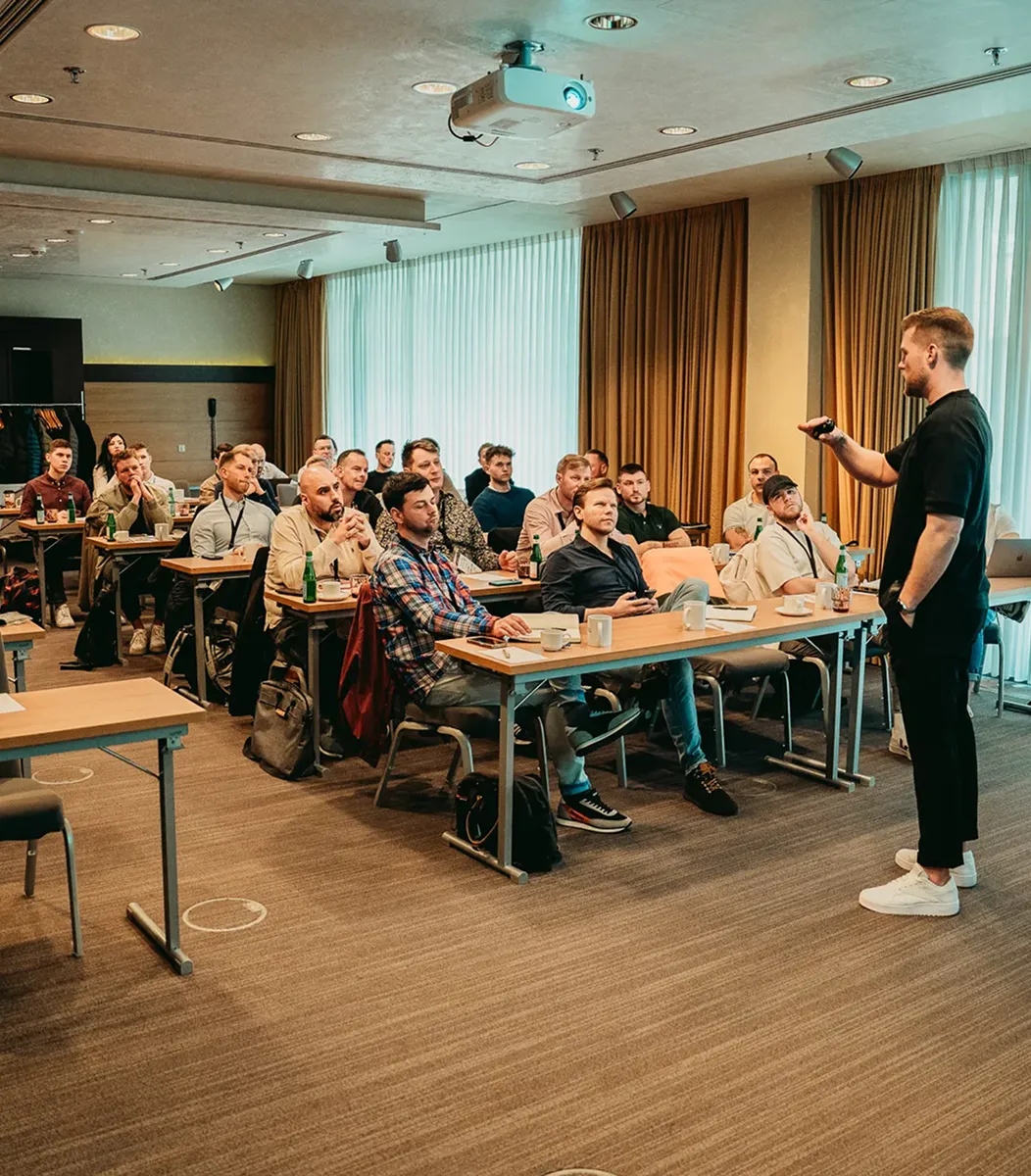 Ein Mann gibt in einem Konferenzraum vor einem Publikum eine Präsentation.