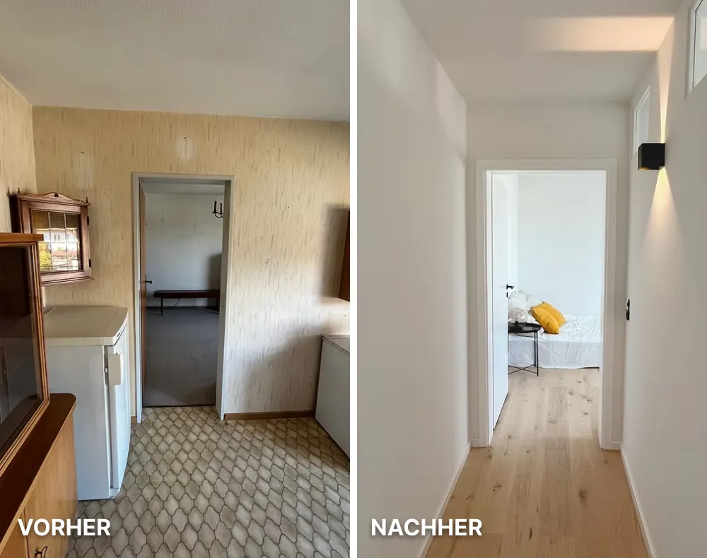 Moderne helle Küche mit weißen Schränken, Holzarbeitsplatte, Kochfeld und großer Fensterfront mit Blick auf Nachbarhäuser.