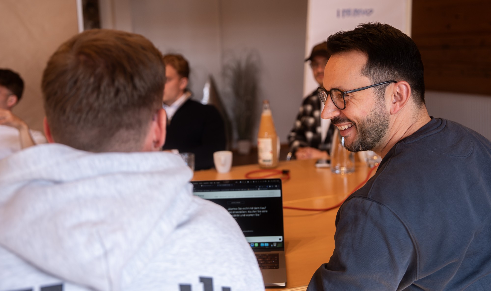 Menschen unterhalten sich in einem hellen Raum während einer informellen Networking-Veranstaltung.