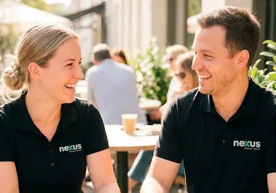 Two Nexus team members smiling at an outdoor cafe