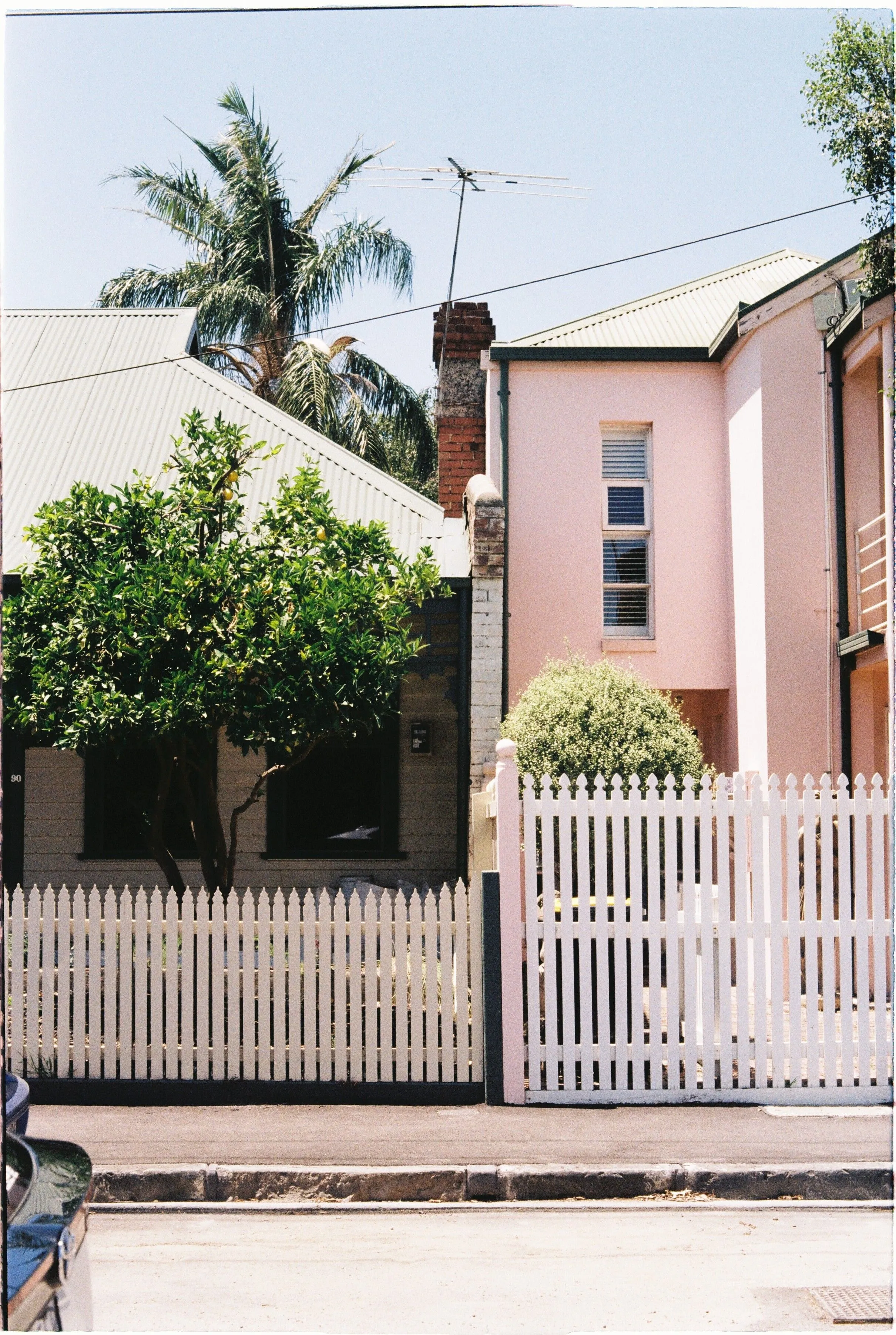Two-storey terrace house with a white picket fence