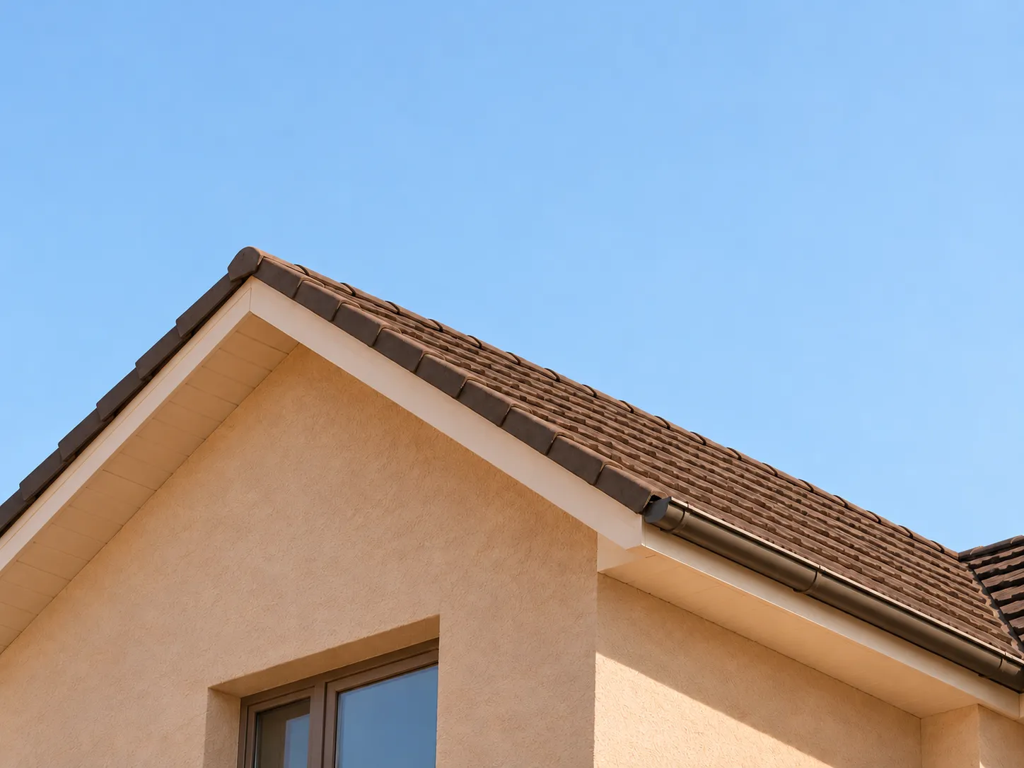 Tiled roof and rendered wall of a Sydney home against a blue sky