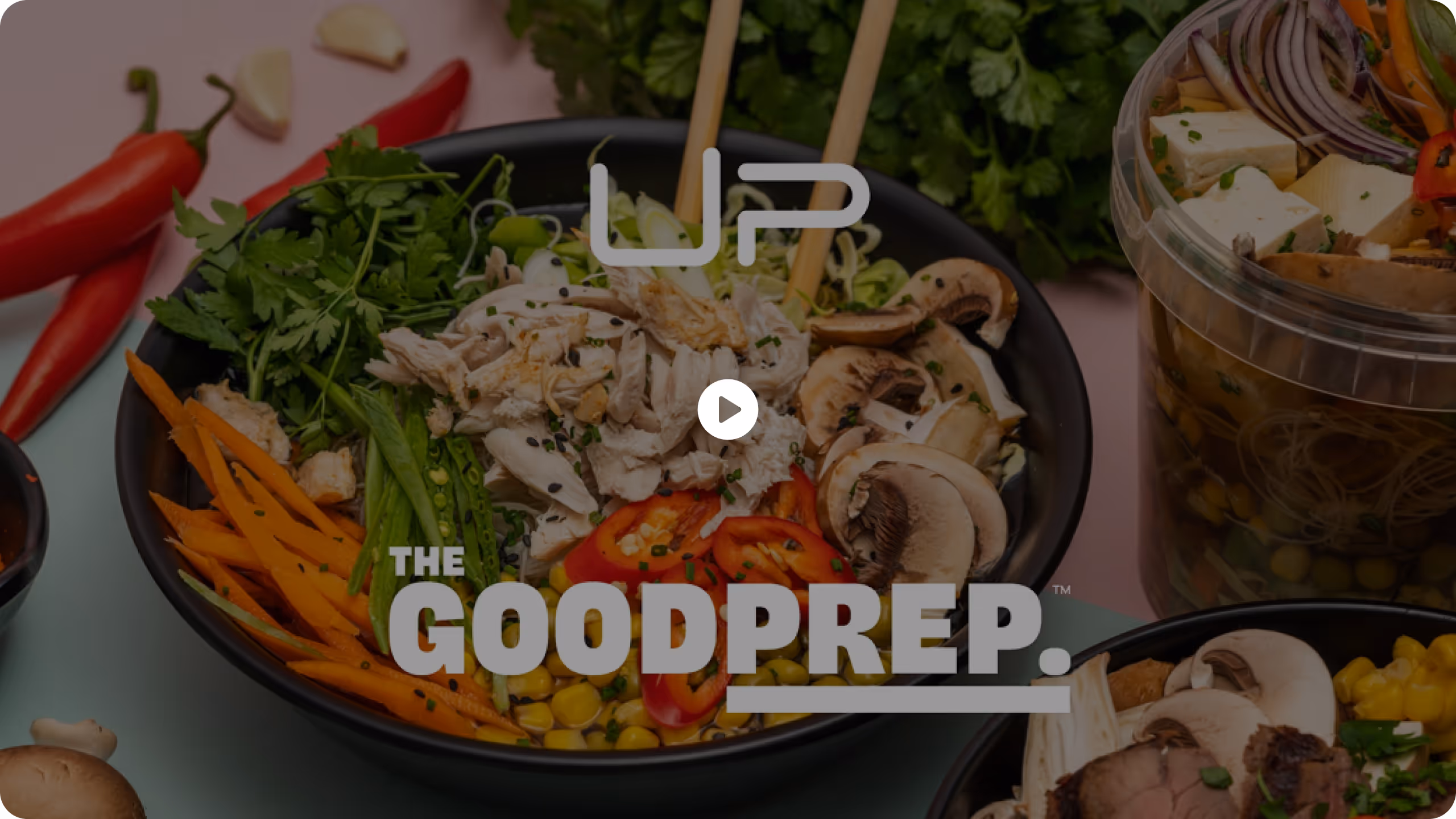 Black bowl filled with shredded chicken, sliced mushrooms, red peppers, corn, carrots, and green herbs.