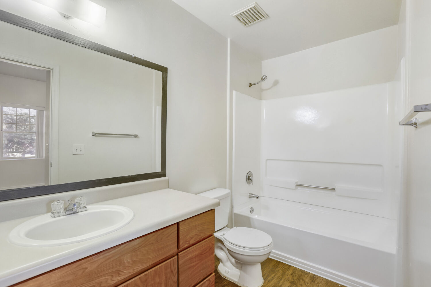 Bathroom with tub and white cabinets