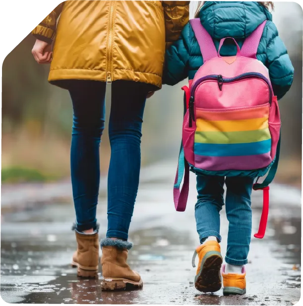Parent and child walking together, colorful rainbow backpack on rainy day