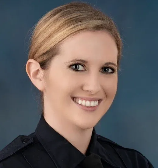 Smiling professional woman in black shirt against blue background