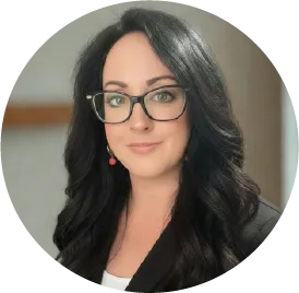 Professional headshot of a woman wearing glasses and black jacket