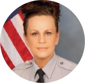 Military or government official in uniform standing in front of American flag