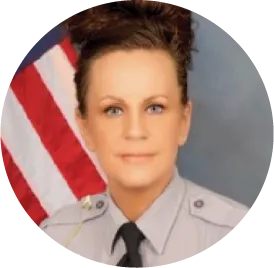 Military or government official in uniform standing in front of American flag