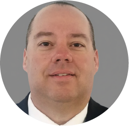 Professional headshot of a middle-aged man smiling in business attire