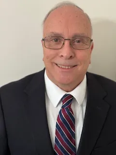 Smiling professional in black suit and striped tie wearing glasses