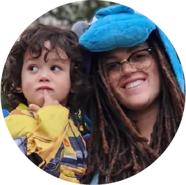 Smiling person with dreadlocks and child in yellow jacket and blue hat