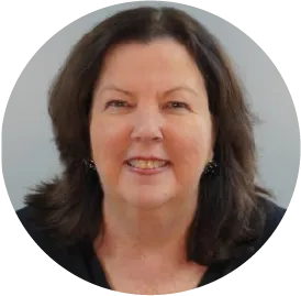 Smiling professional woman with shoulder-length dark hair against gray background