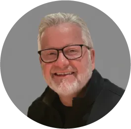 Smiling older man with glasses and gray beard wearing black sweater