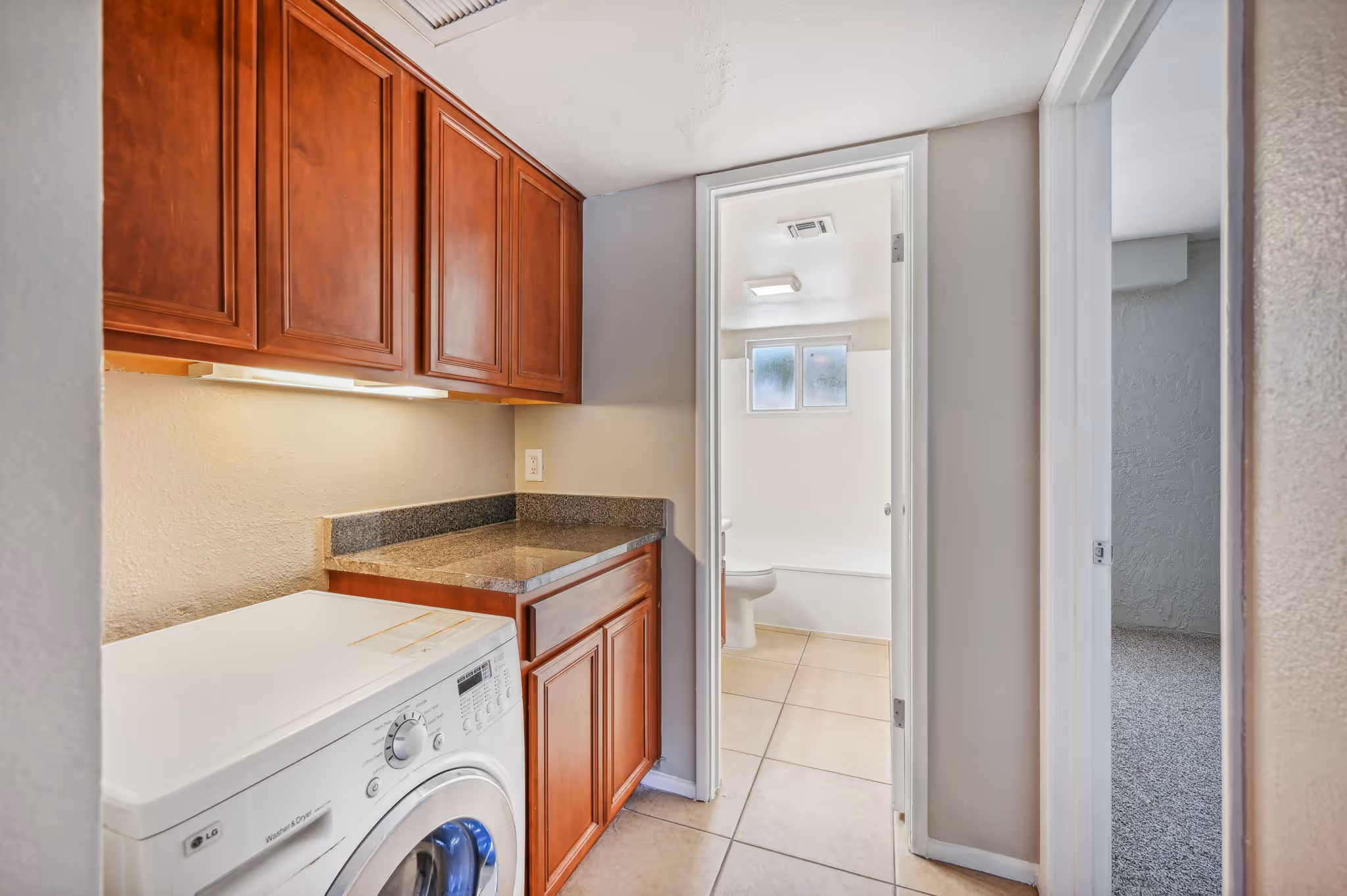 Laundry room with brown cabinets and washing machine