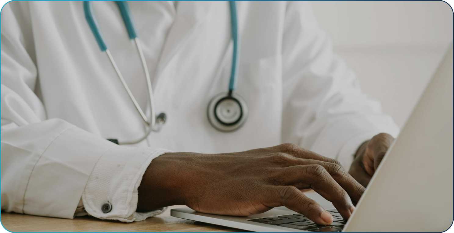 Grayscale close-up of hands typing on a backlit computer keyboard.