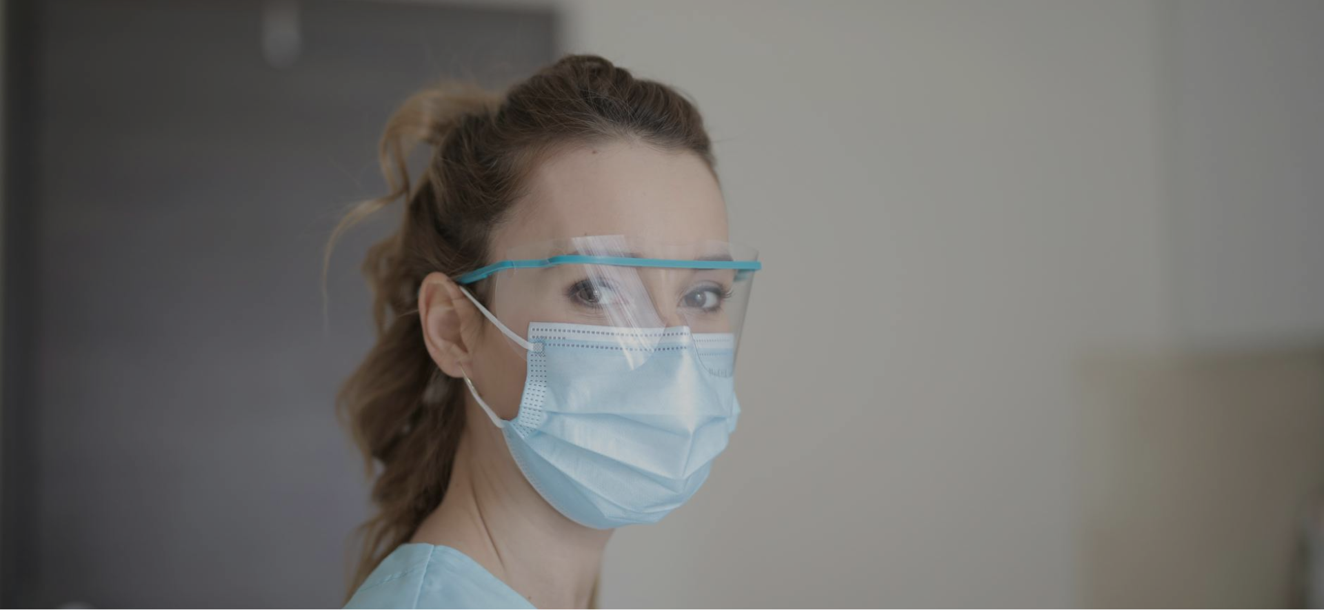 Grayscale close-up of hands typing on a backlit computer keyboard.