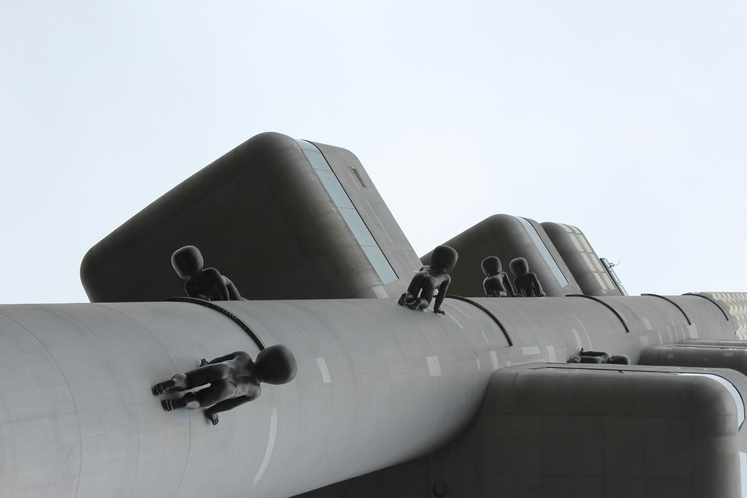 Grayscale close-up of hands typing on a backlit computer keyboard.