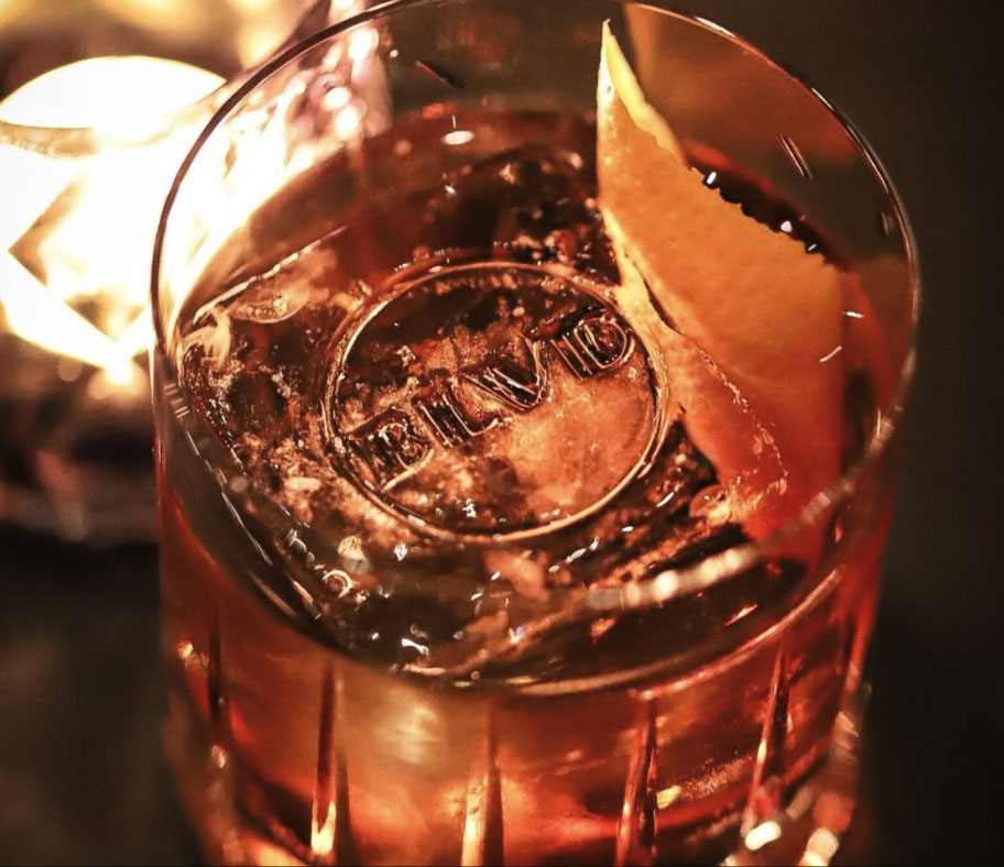 A whiskey glass with a BLVD stamped ice cube in the center