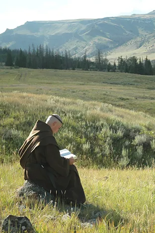 Hiker reading in mountain valley landscape