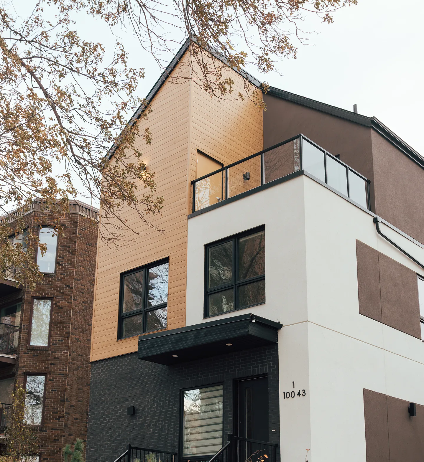 A white and brown building with a black door.