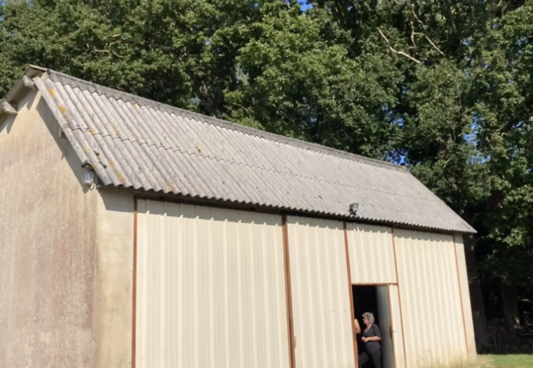 Ancien toit gris clair, fibrociment terne, taches foncées, zones noircies, ciel dégagé Donchery.