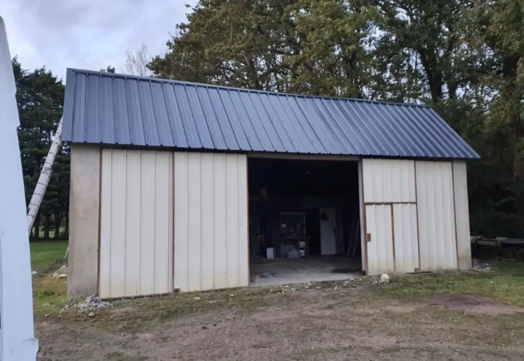 Nouvelle toiture bac acier gris anthracite, aspect lisse et uniforme, temps sec, bâtiment en bordure forêt Donchery.