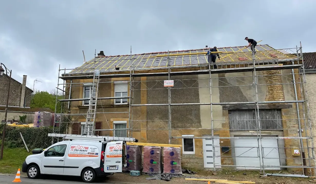 Anciennes gouttières noircies, affaissées, traces de débordement, ciel nuageux à Donchery.