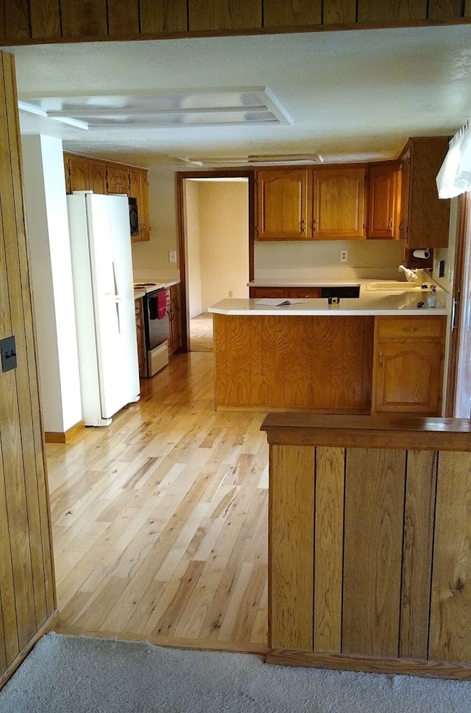 Vintage kitchen with warm wood paneling and cabinetry, showcasing a cozy, rustic design.