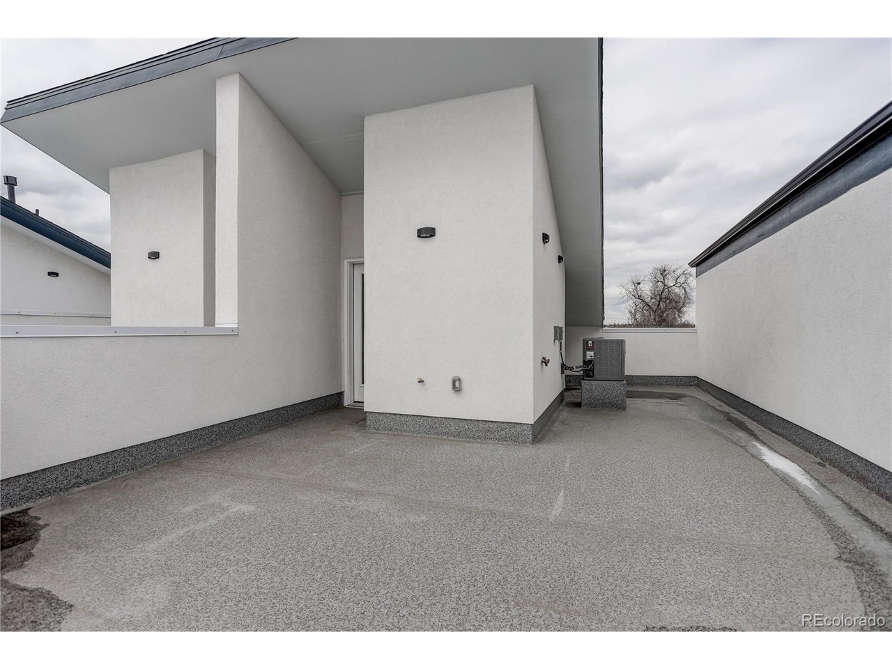 Private rooftop terrace designed by Denver Dream Builders, showcasing clean white walls and a spacious layout, part of the 10 townhomes project.