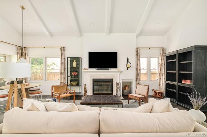 Living area of a Hilltop Denver remodel featuring a central fireplace, modern furniture, and large windows for natural light.