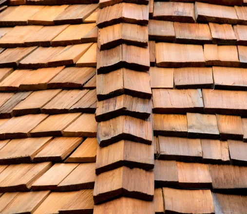 Completed cedar shake roof with neat amber wood shingles and a finished ridge detail
