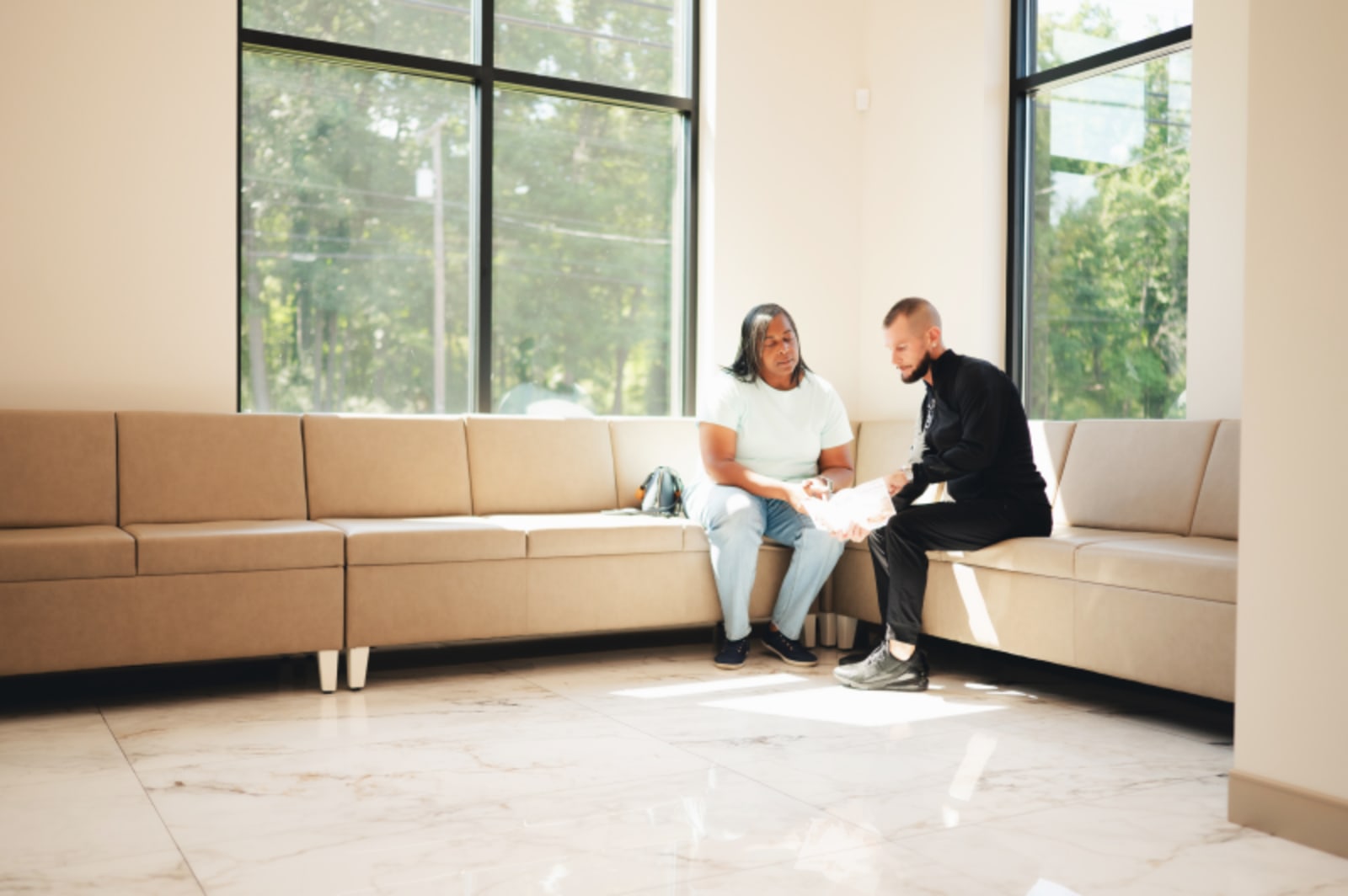 Female patient smiling in modern dental office waiting area with natural light