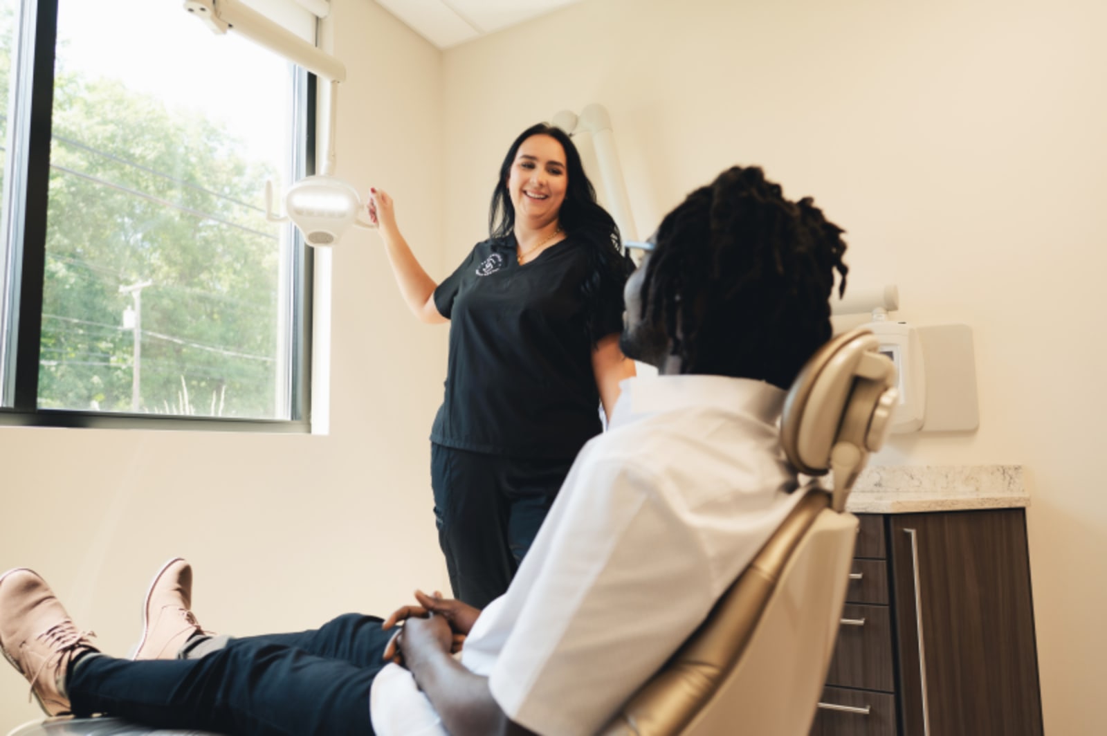 Female dentist discussing treatment plan with patient in examination chair