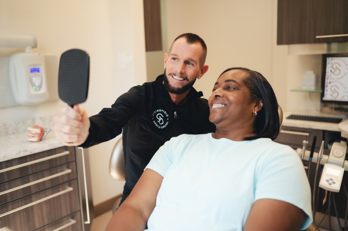 Dentist performing oral examination on patient in clinical treatment room