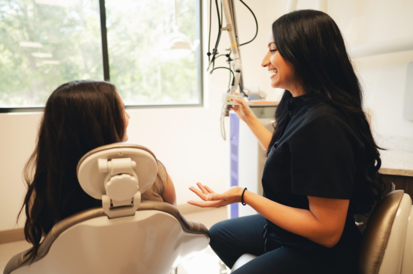 Dental professional showing model to patient during implant planning