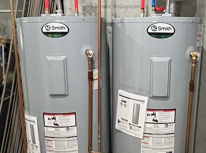 Two A.O. Smith water heaters installed side-by-side with new copper piping and expansion tank.