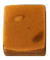 Square piece of caramel fudge with a smooth surface and a few darker spots.