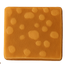 Square piece of brown fudge with lighter circular spots on the surface.