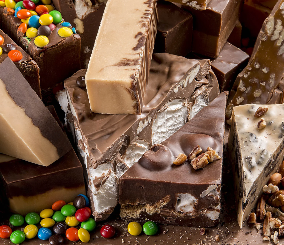 Assorted chocolate and fudge pieces with colorful M&M candies scattered around.