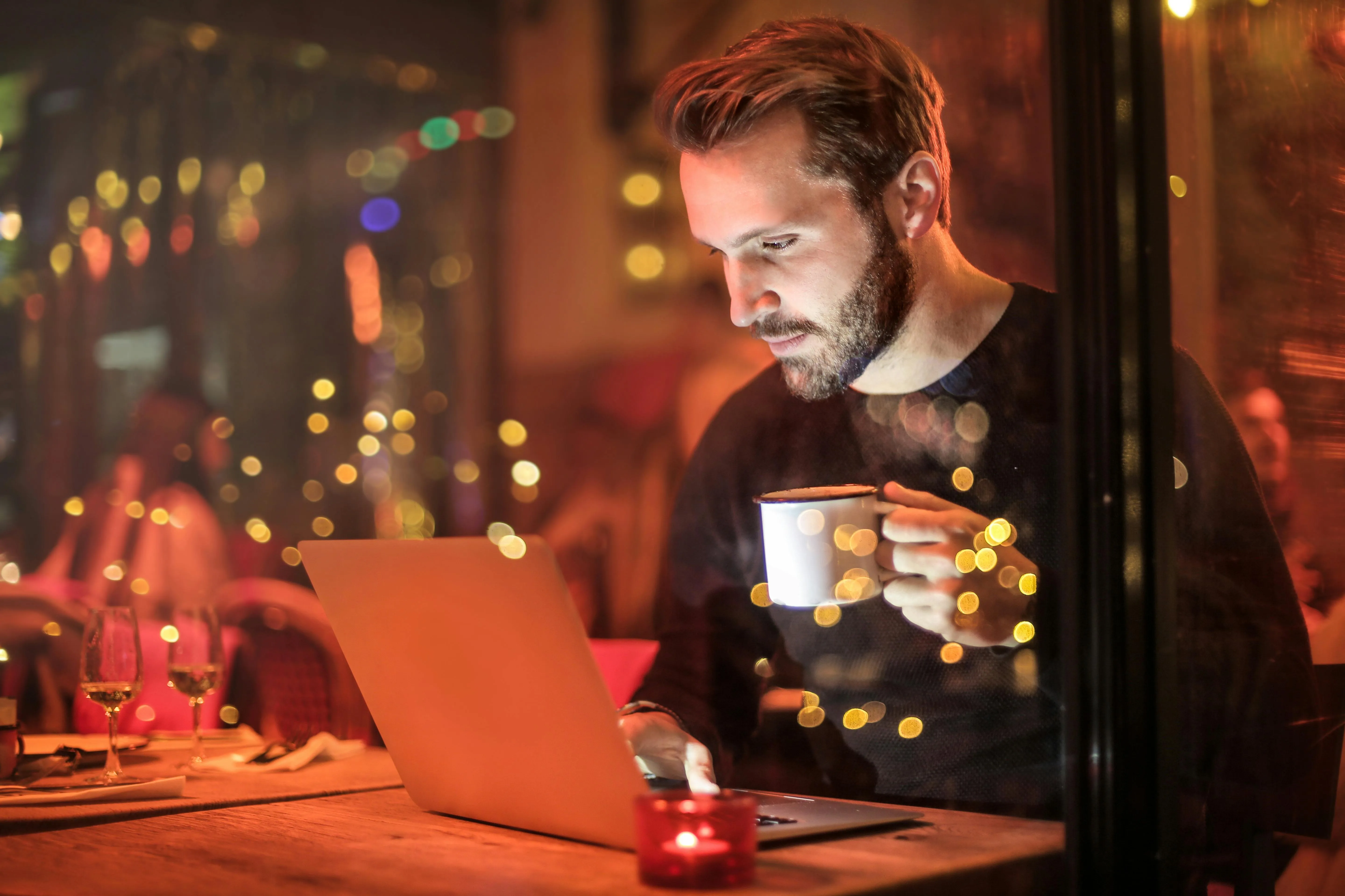 guy on computer with drink stock image