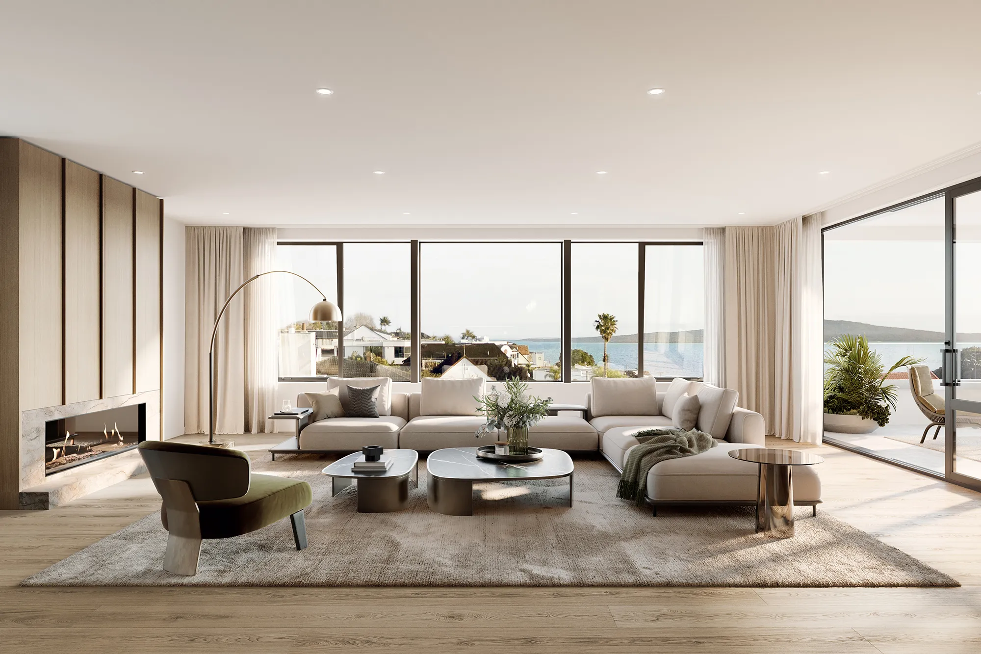 Modern living room with beige sectional sofa, olive accent chair, marble coffee tables, and large windows showing ocean view.