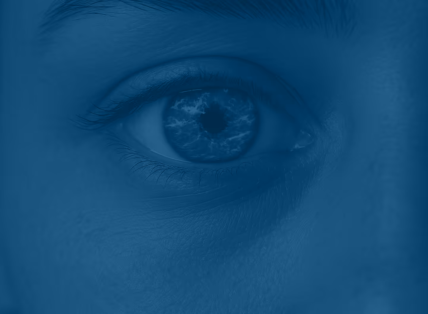 Close-up of a human eye with a reflection resembling swirling clouds or smoke in the iris.
