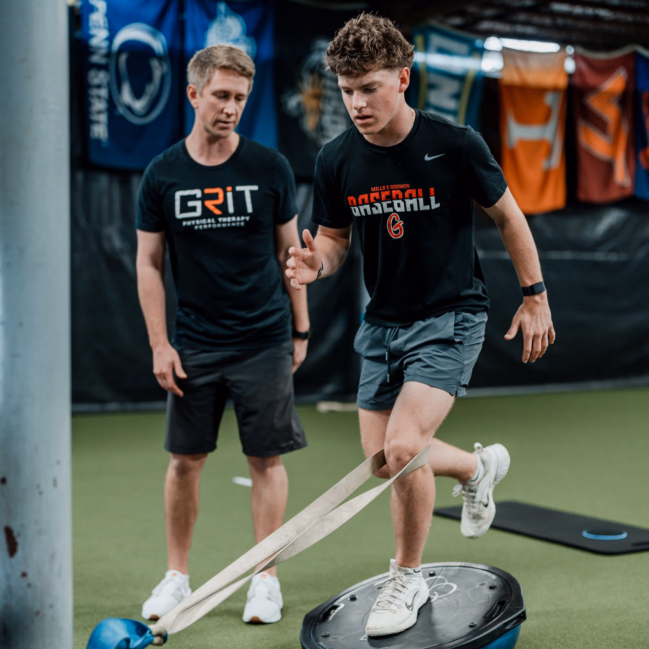 Young athlete balancing on a BOSU ball while exercising with a resistance band in a Richmond, VA physical therapy clinic.