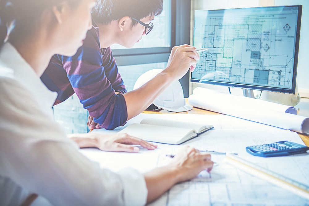 Architect working on a building blueprint, representing workflow redesign