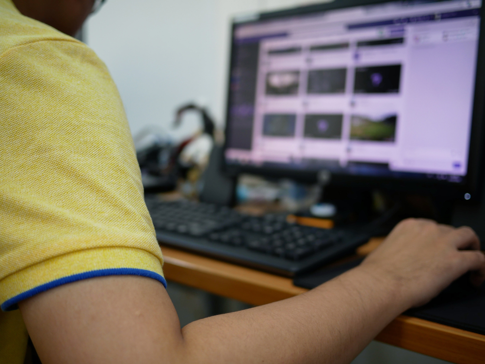 A manager reviewing information on a computer to translate strategy into weekly action