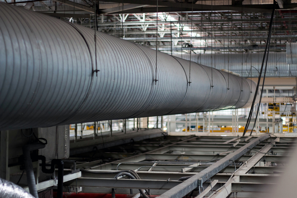 Ventilation ductwork hanging from a ceiling — the hidden systems behind how work actually gets done