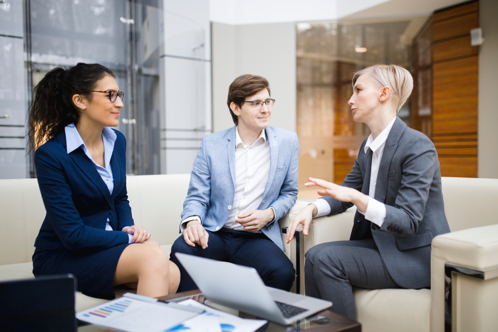 Colleagues discussing charts and business metrics in an office