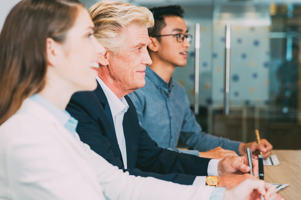 Three colleagues listening during a team meeting