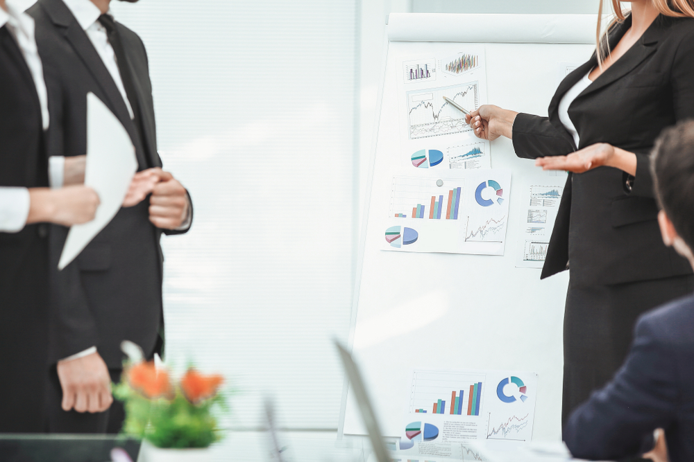 A leader presenting performance charts and scorecard metrics to colleagues